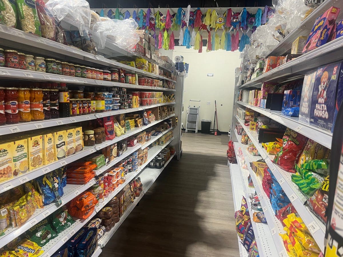 Grocery aisle with piñatas hanging from ceiling at Los Portales Supermarket